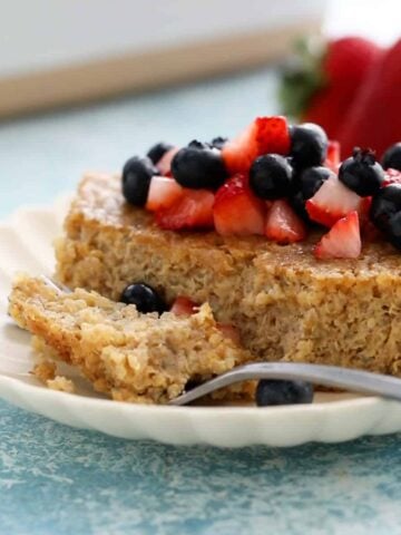 one slice of quinoa breakfast bake in a white plate along with a fork.