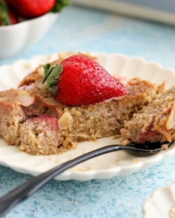 a slice of baked quinoa in a white plate along with a black fork.