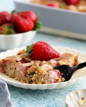 a slice of baked quinoa in a white plate along with a black fork.