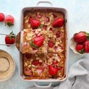 quinoa baked in a grey pan topped with pink strawberries.
