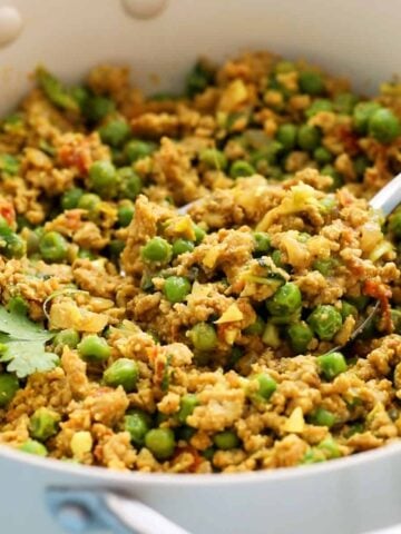 cooked chicken keema with green peas in a white skillet.