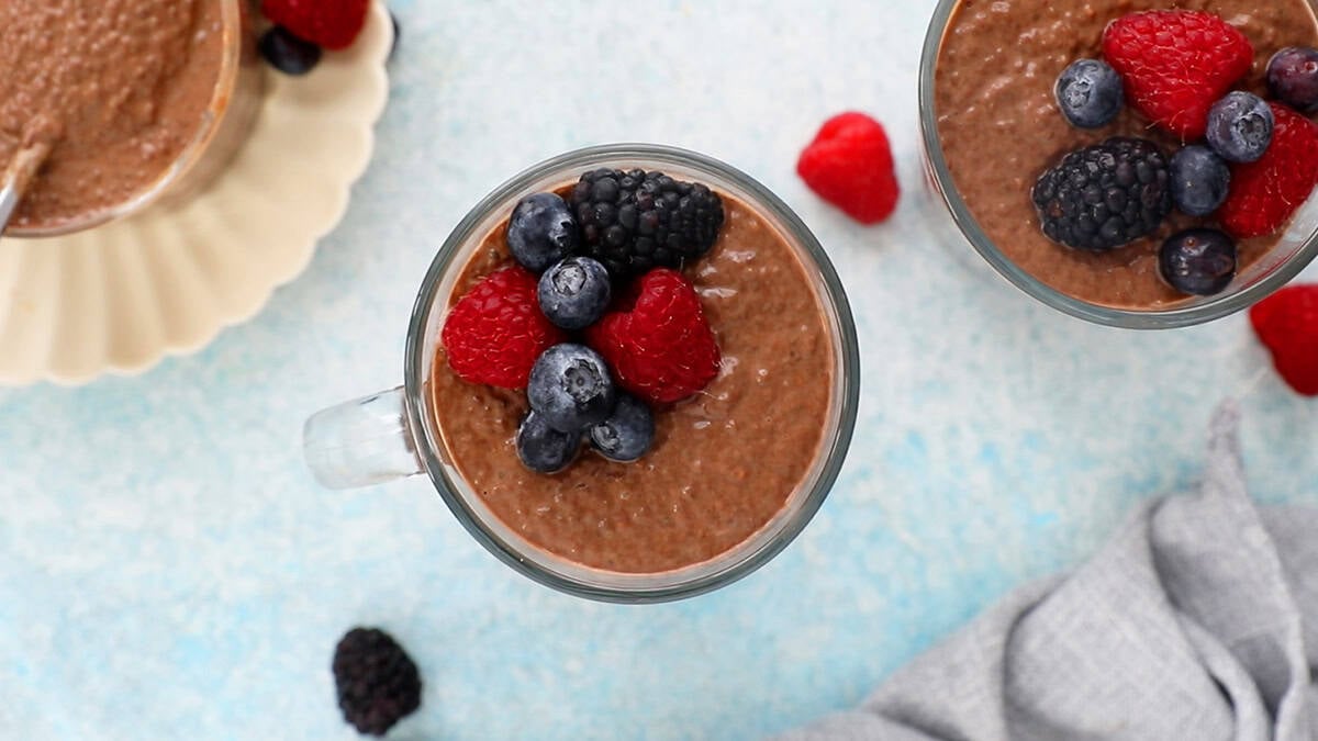 chocolate chia pudding topped with berries in a glass jar.