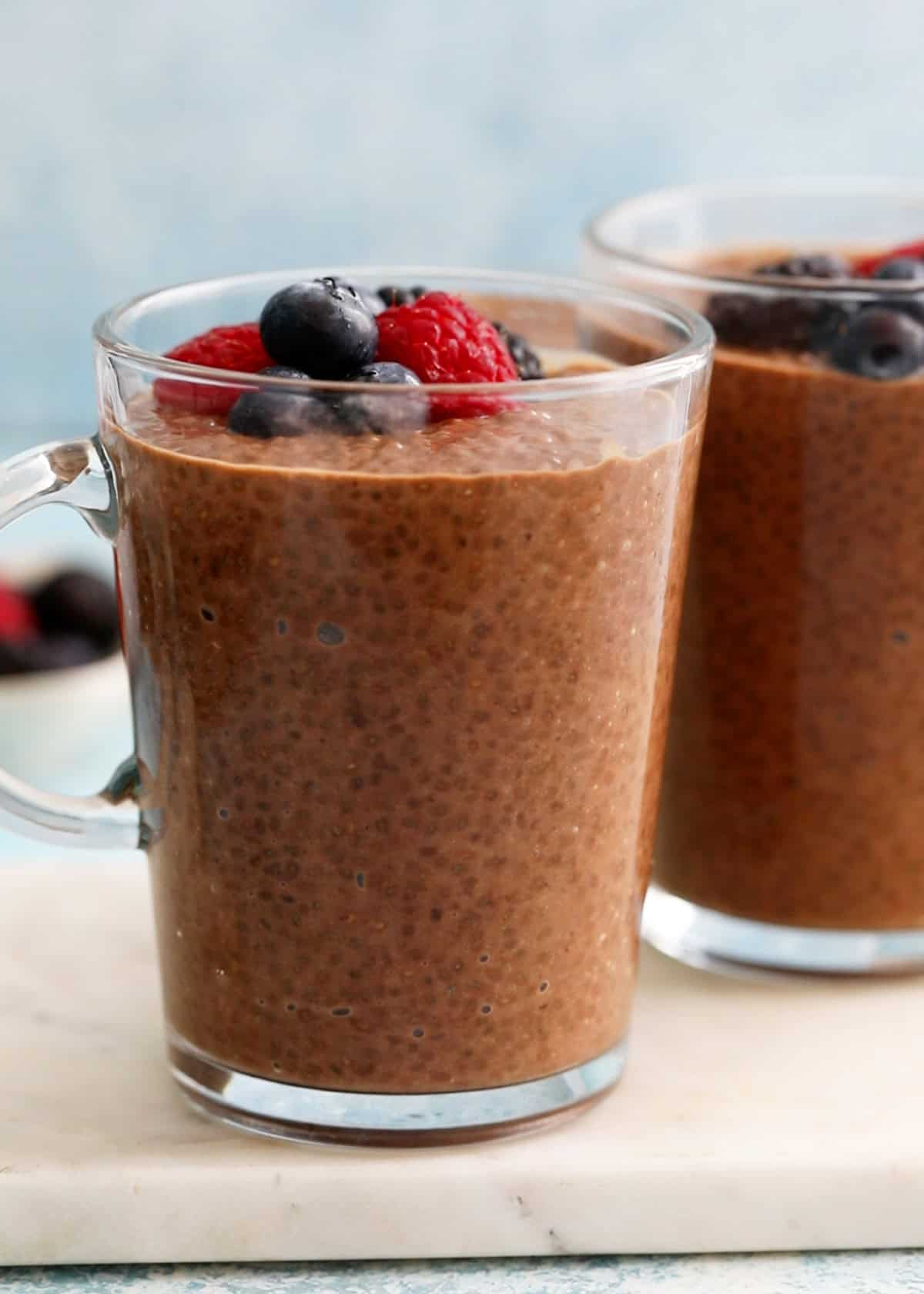chocolate chia pudding topped with berries in a glass jar.