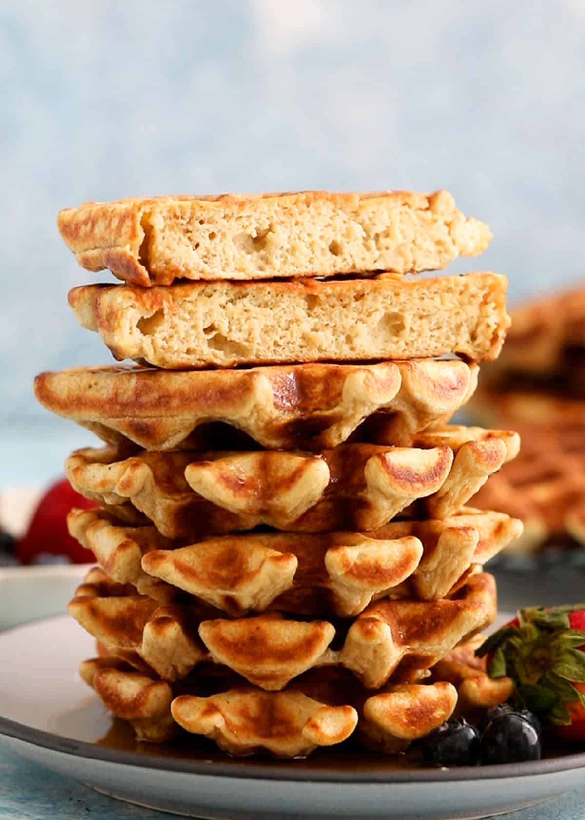 6 cottage cheese waffles stacked on a grey plate.