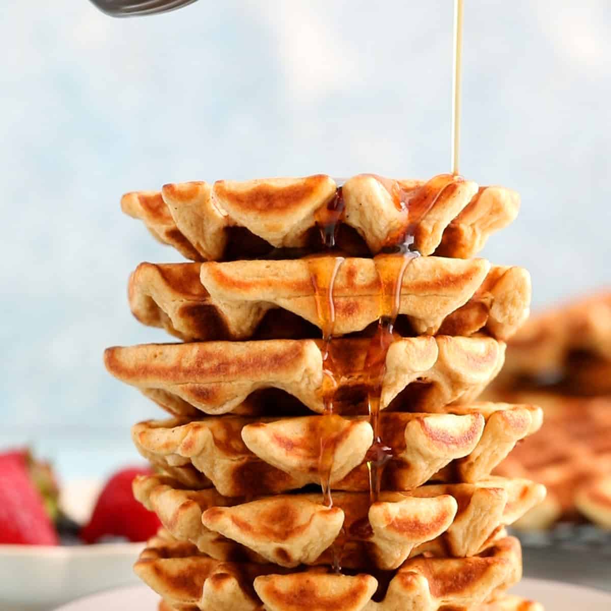 6 cottage cheese waffles stacked on a grey plate.