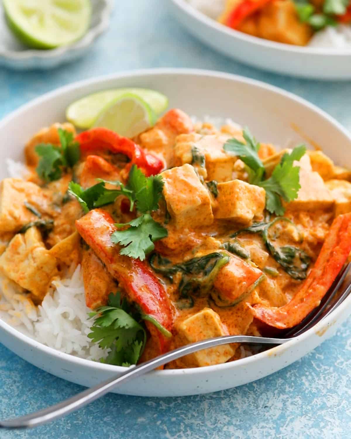 Thai red tofu curry with white rice in a white bowl.