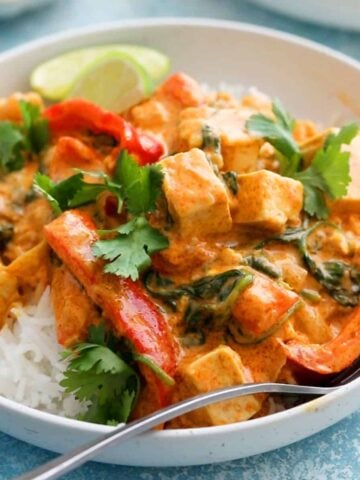 Thai red tofu curry with white rice in a white bowl.