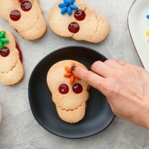 one skull cookie on a black plate.