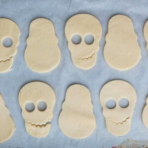 8 skull shaped cookies on a white paper.