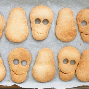 8 skull shaped cookies on a white paper.