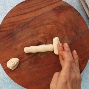one bone shaped cookie on a brown board.