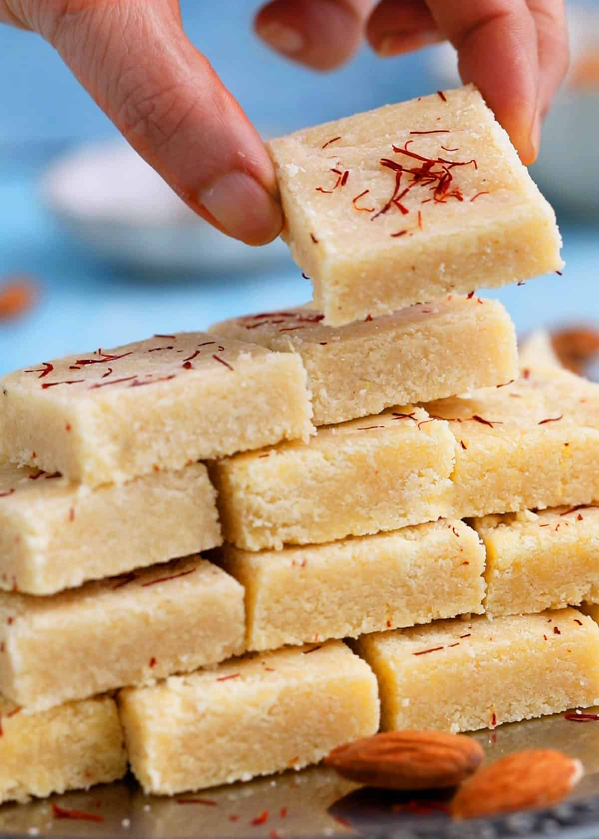 badam burfi piled high on a metal plate.
