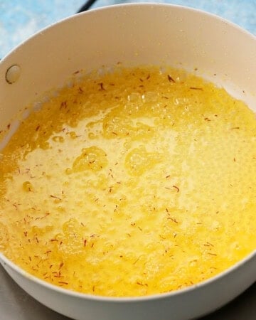 saffron sugar syrup cooking in a  white pan.