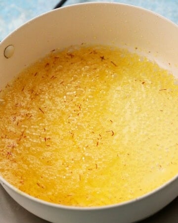 saffron sugar syrup cooking in a  white pan.