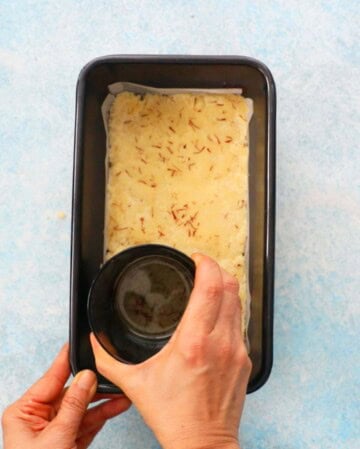 badam burfi in a metal loaf pan.