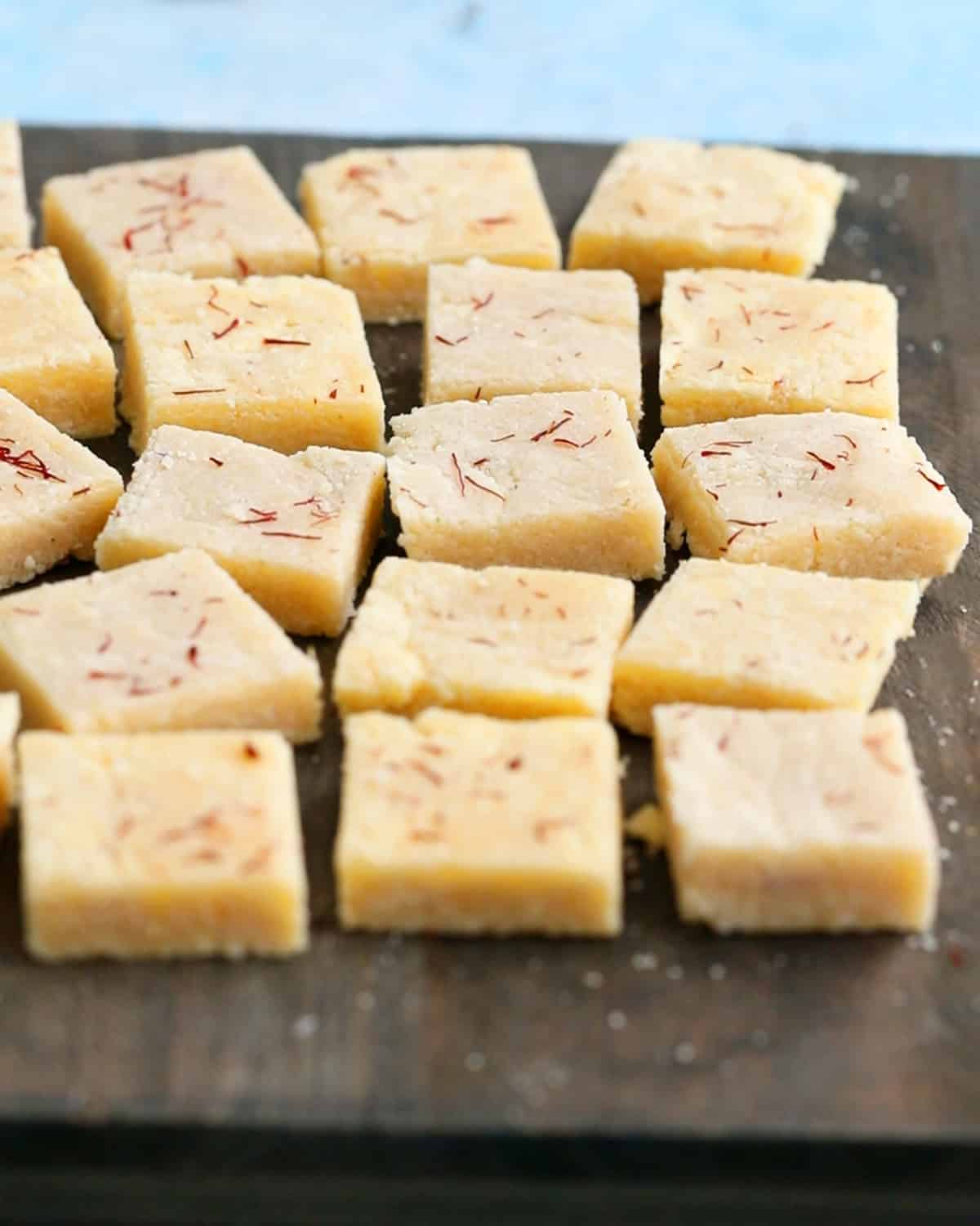 badam burfi on a wooden board.