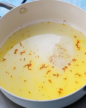 saffron sugar syrup cooking in a  white pan.