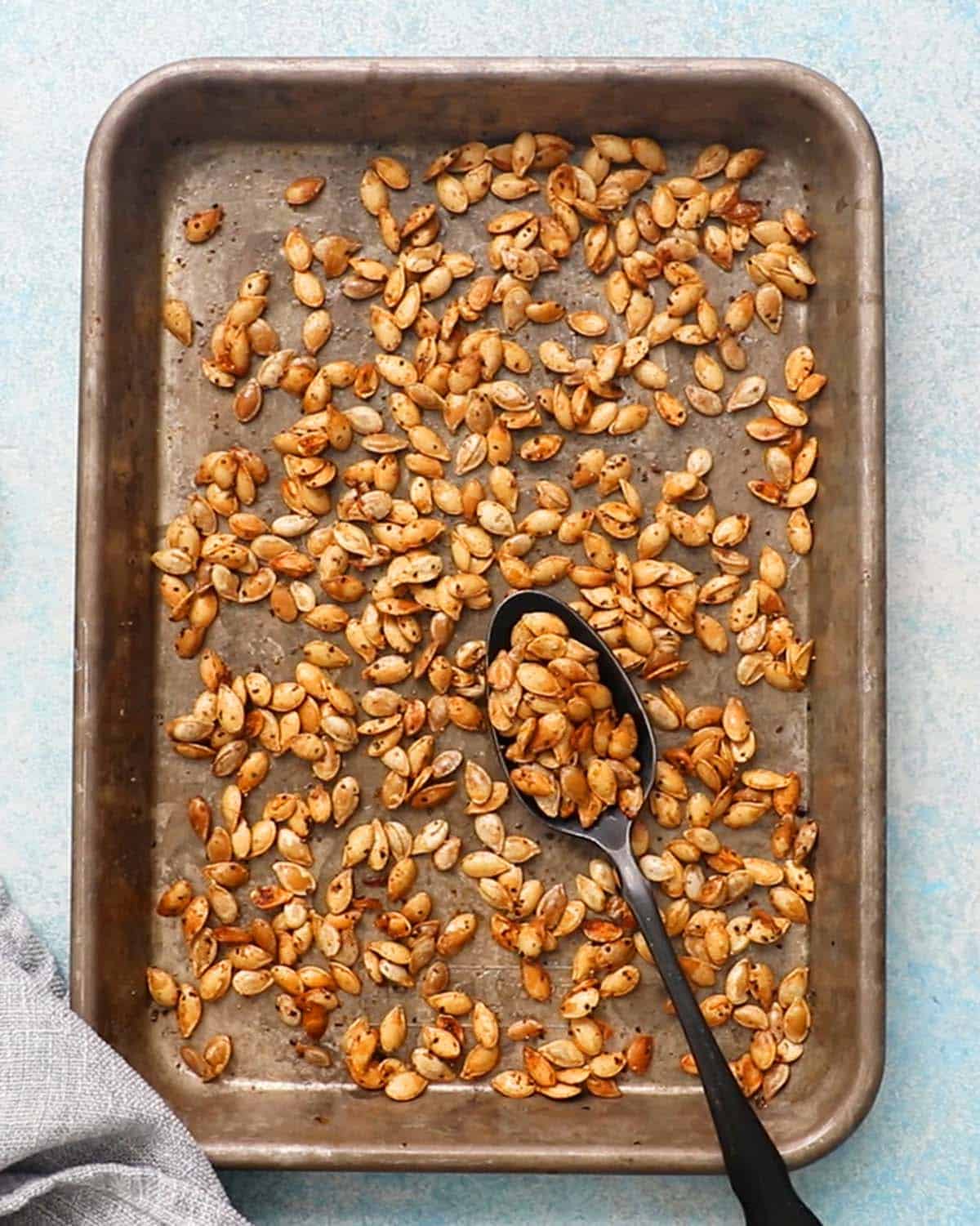 roasted butternut squash seeds in a baking sheet.