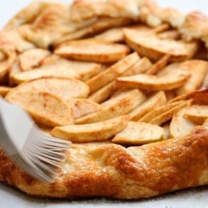 one unbaked apple galette on a white paper.