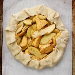 one unbaked apple galette on a white paper.
