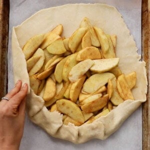 one unbaked apple galette on a white paper.