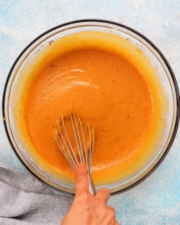 butternut squash pie filling ingredients in a glass bowl along with a whisk.