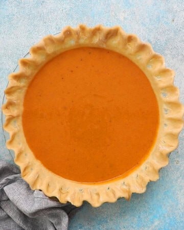 an unbaked butternut squash pie in a pie dish.