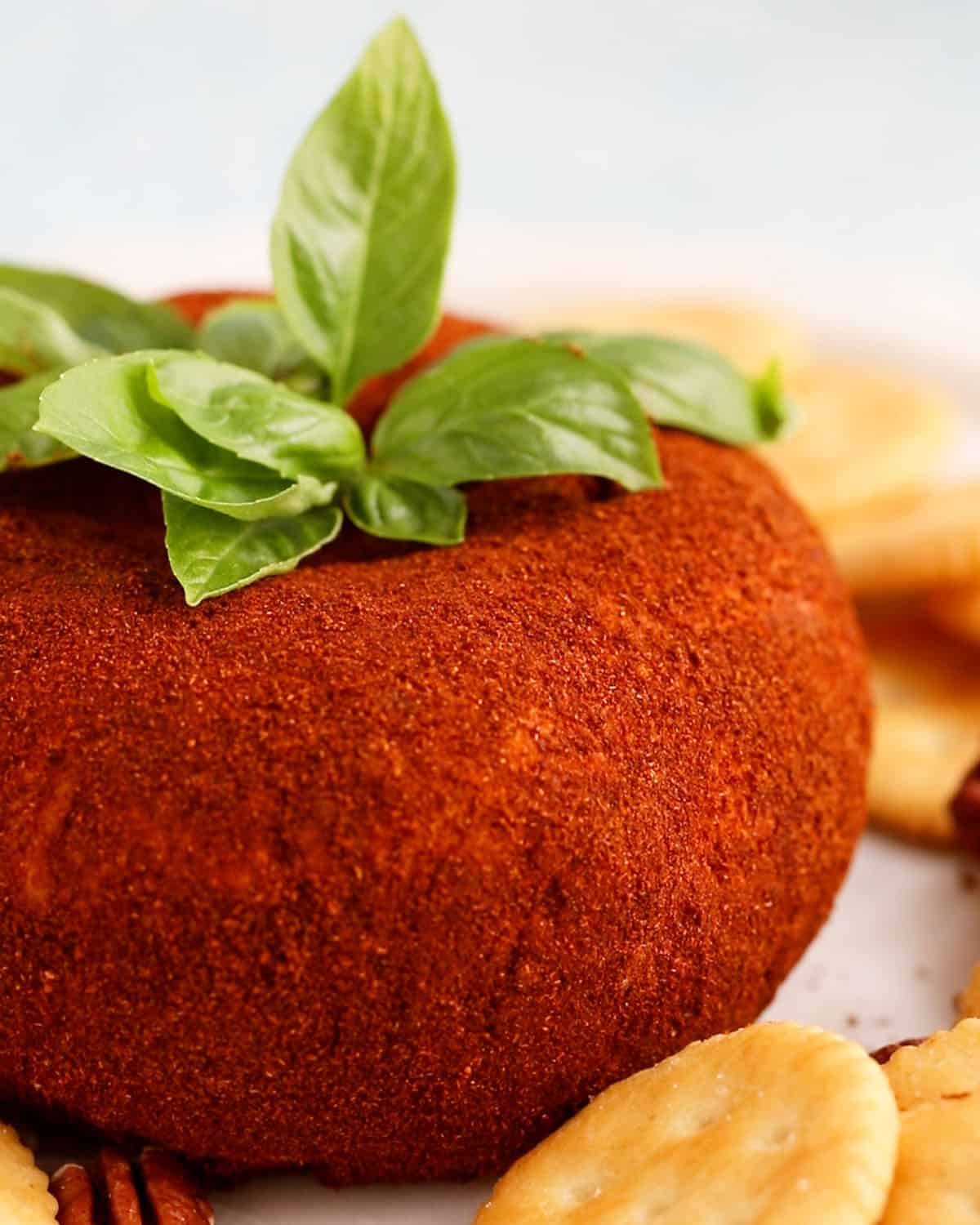 one tomato shaped cheese ball on a white platter.