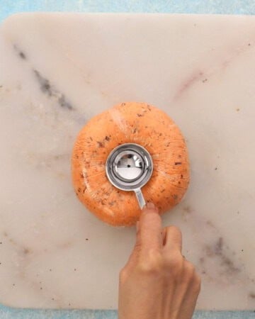 two hands shaping a tomato cheese ball.