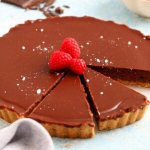 one chocolate tart topped with raspberries.