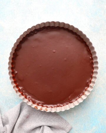 one brown chocolate tart in a tart pan.
