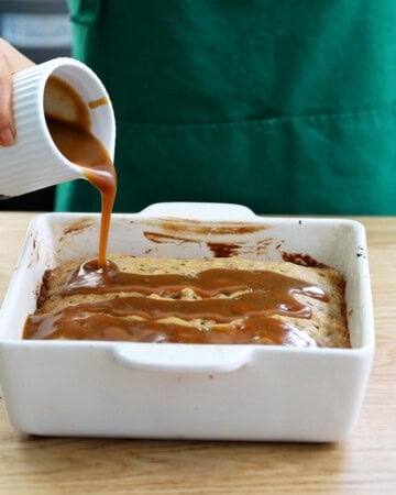 brown date cake in a white baking dish.