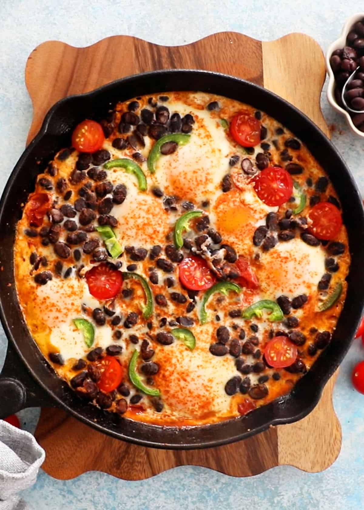 baked eggs in black skillet.