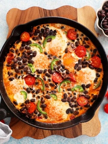 baked eggs in black skillet.