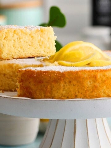one almond flour lemon cake in a white cake stand.