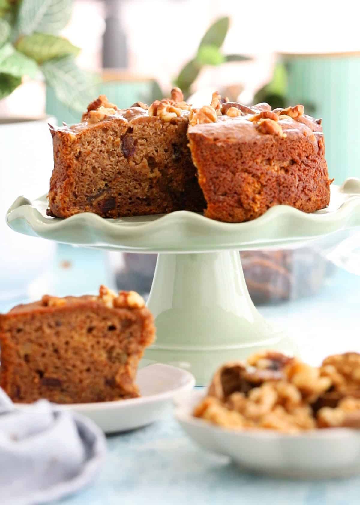 one brown date and walnut on a green cake stand.