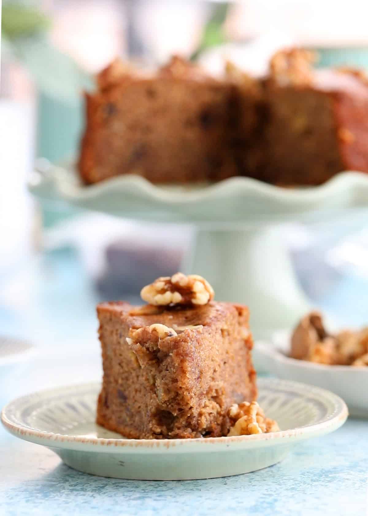 one slice of brown date cake in a green plate.