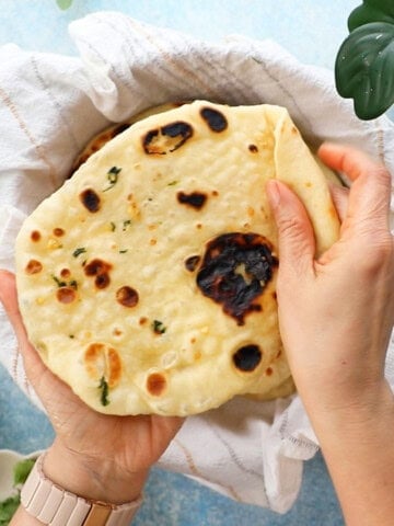 two hands holding one naan.