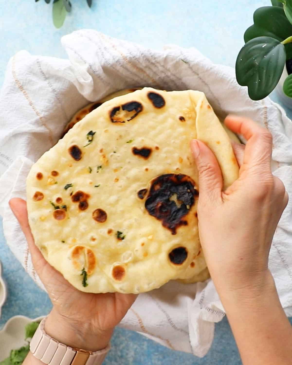 two hands holding one naan.