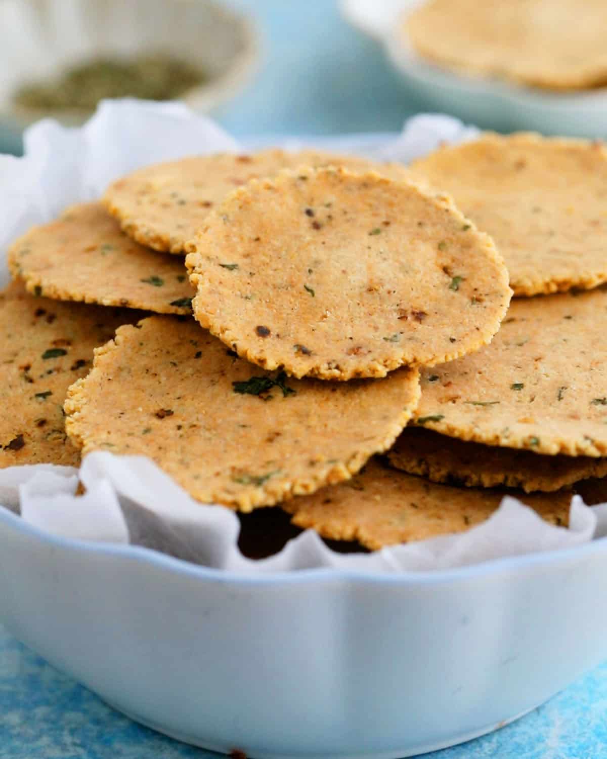 round almond flour crackers in a white bowl.