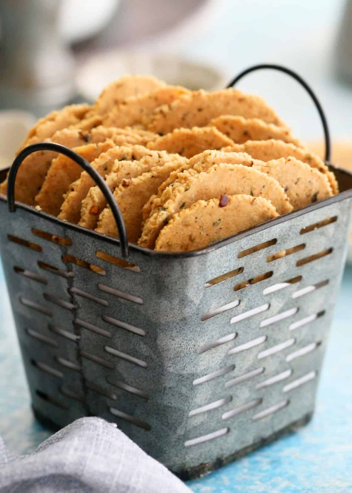 round almond flour crackers in a small metal bucket.