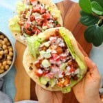 two hands holding a chickpea and cauliflower wrap.