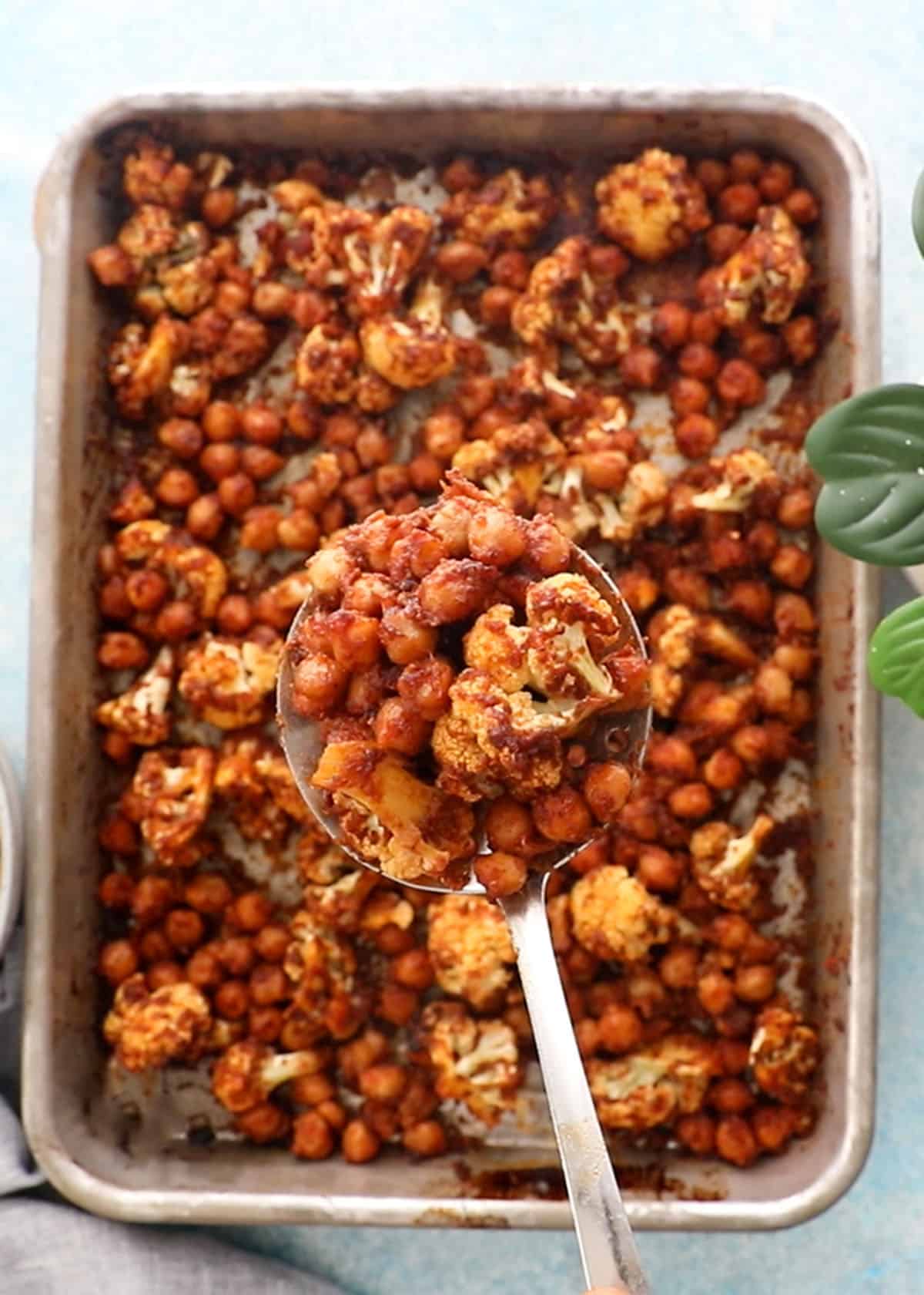 two hands holding one chickpea and cauliflower wrap.