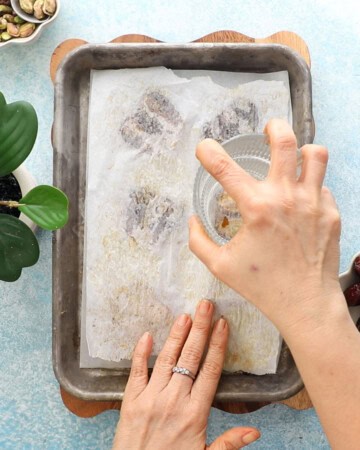 6 brown dates in a metal sheet pan.