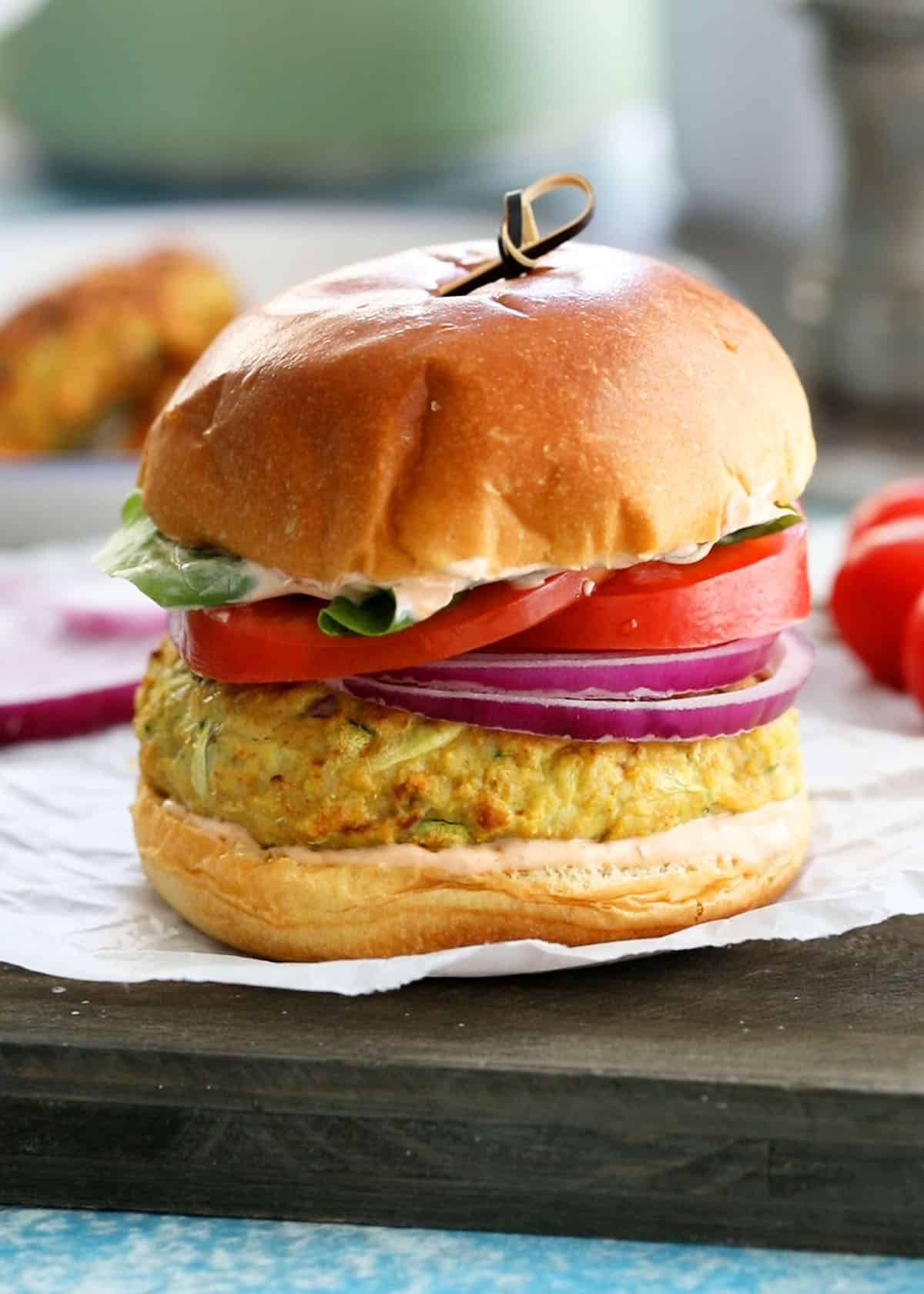 one chicken zucchini burger placed on a white paper.