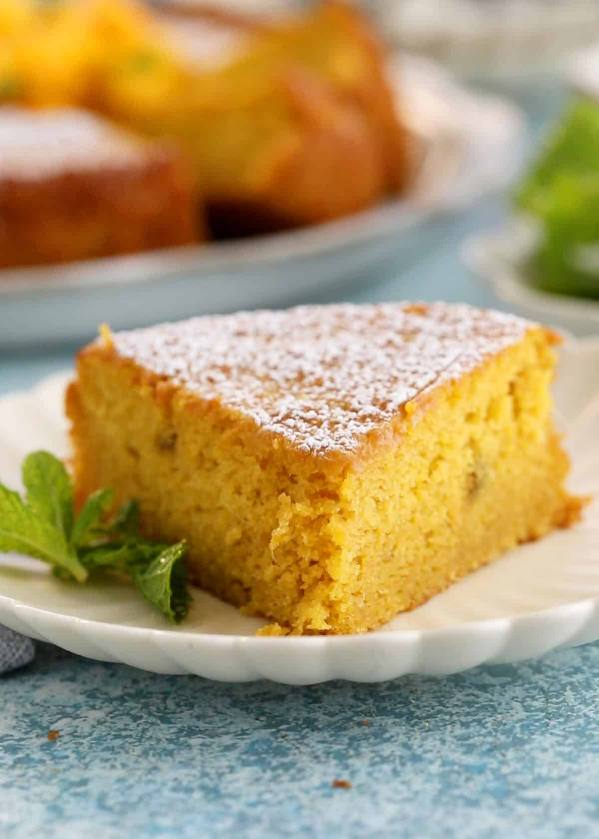 one slice of yellow mango cake in a white plate.
