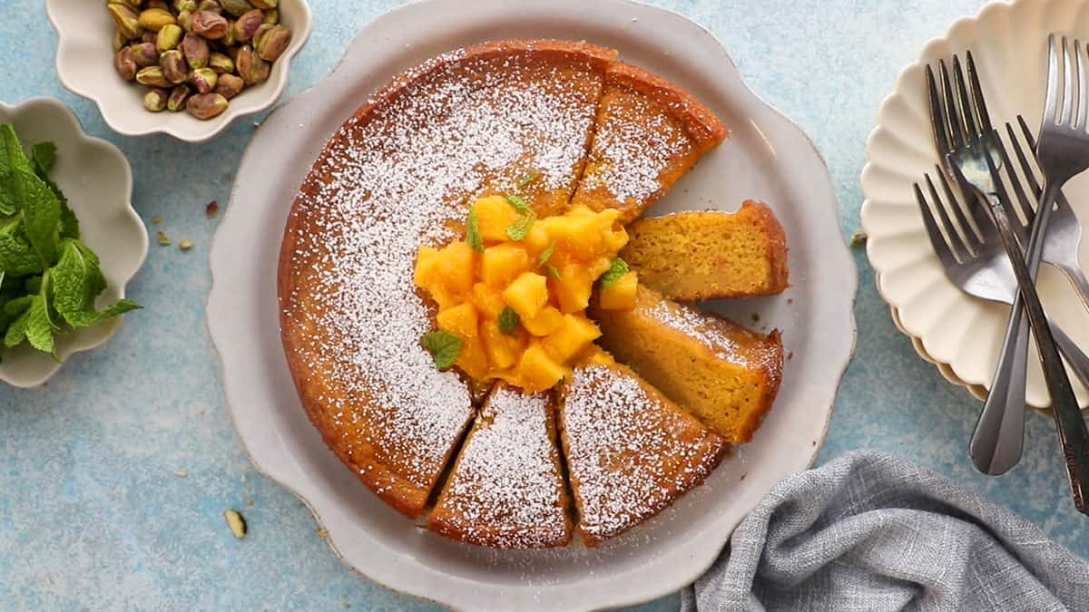 one yellow mango cake in a white platter.