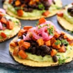 sweet potato and black bean tacos on a black platter.