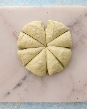 yellow color naan dough on a white square marble.