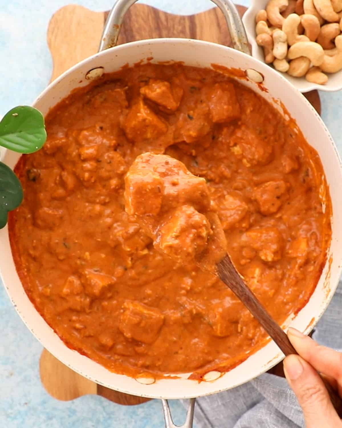 orange tofu tikka masala in a white pan.